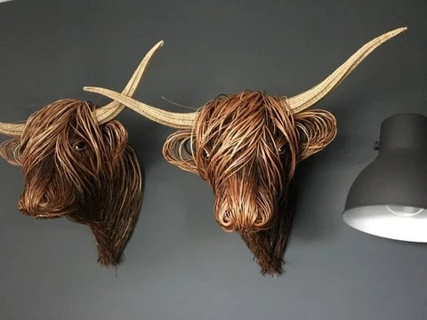 Rustic handcrafted cow head wall decor shown as a wall-mounted sculpture