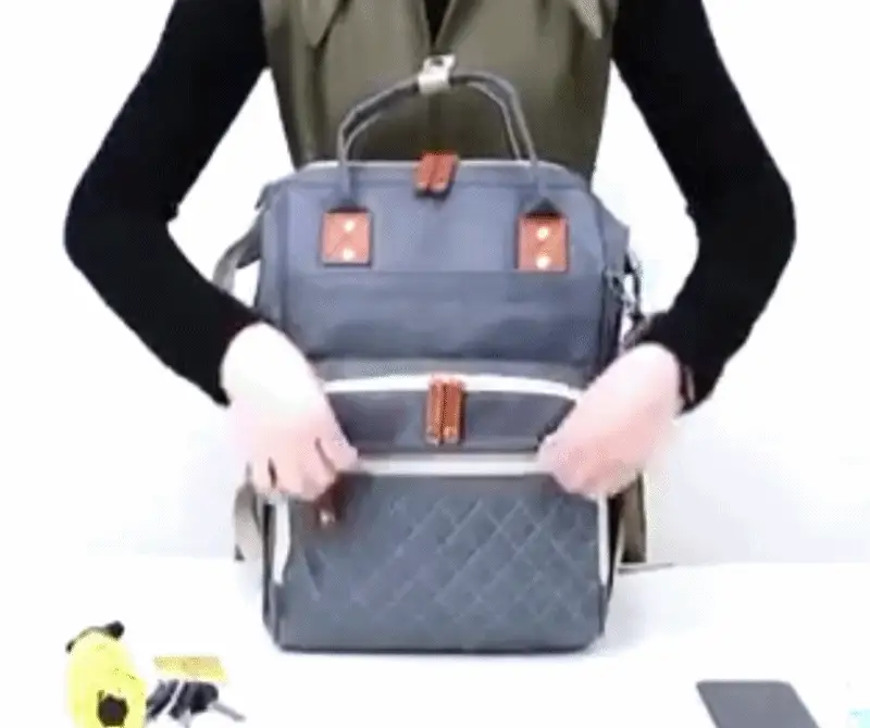 Diaper backpack with foldable baby bed in use